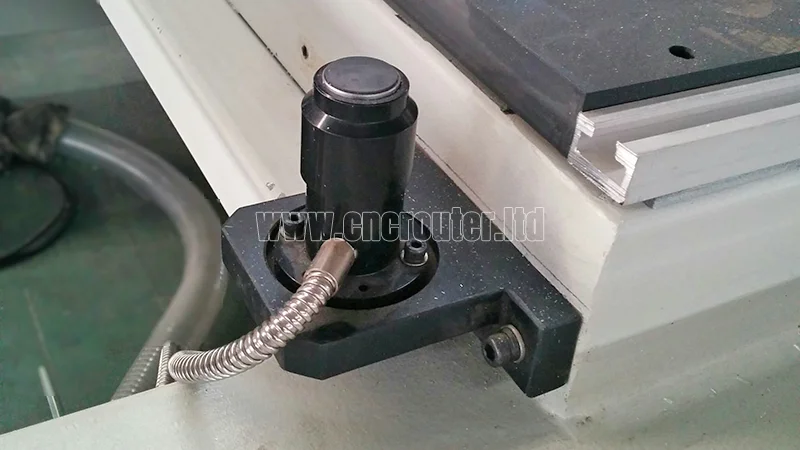 un sensor de longitud de herramienta negro montado junto a la plataforma de trabajo del enrutador cnc de 4 ejes.jpg